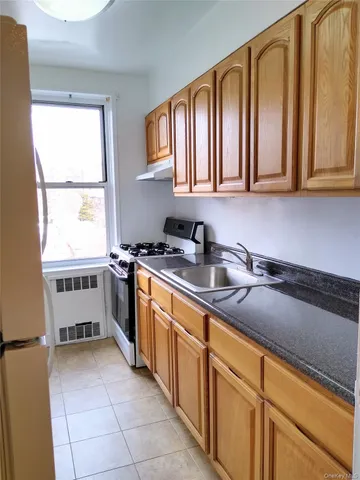 a kitchen with stainless steel appliances granite countertop a sink a stove and cabinets