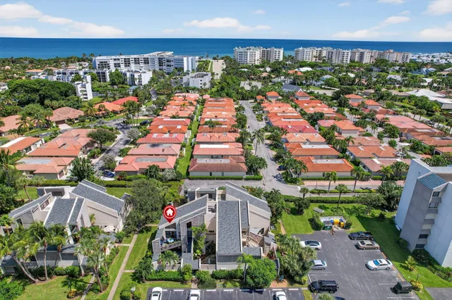 an aerial view of a city with lots of residential buildings ocean and mountain view in back
