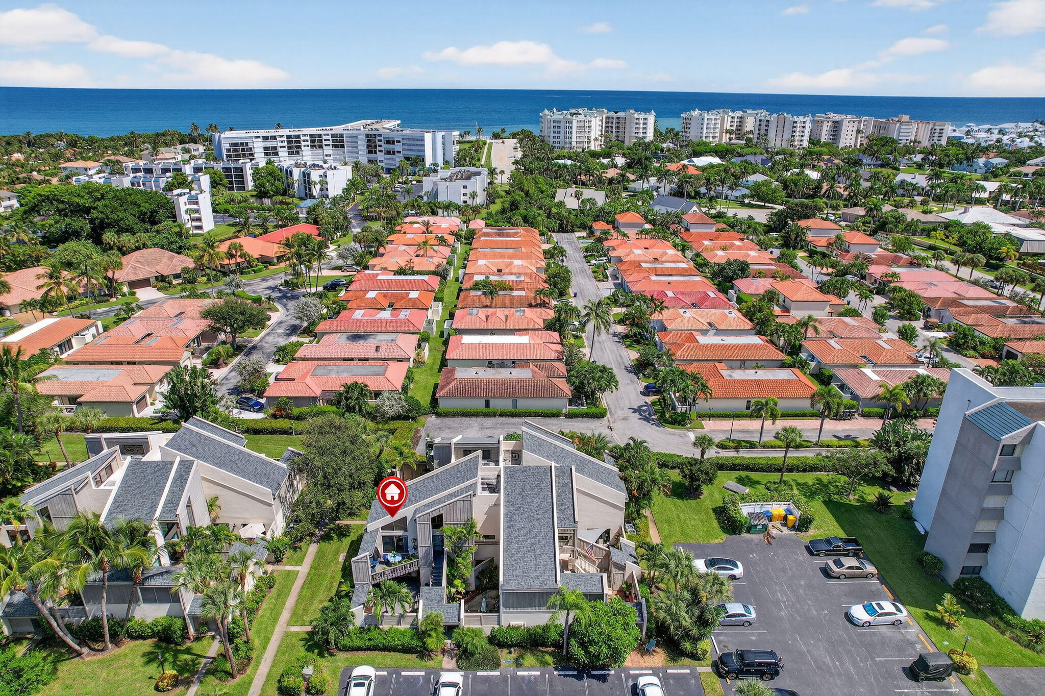an aerial view of a city with lots of residential buildings ocean and mountain view in back