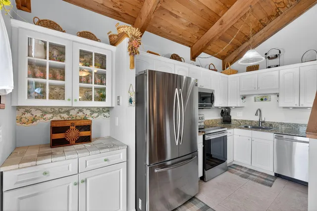 a kitchen with stainless steel appliances granite countertop a refrigerator and a stove top oven