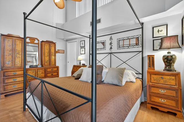 a bedroom with a bed and wooden floor