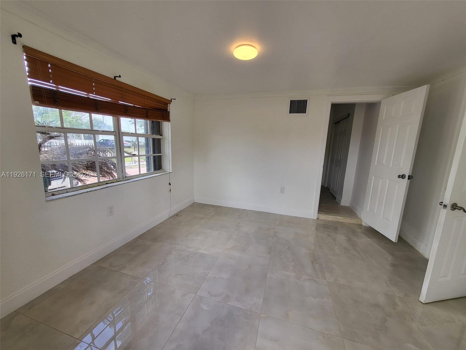 15320 Southwest 298th Terrace, Unit 15320 Homestead, FL 33033 - Photo 25 of 27 an empty room with windows