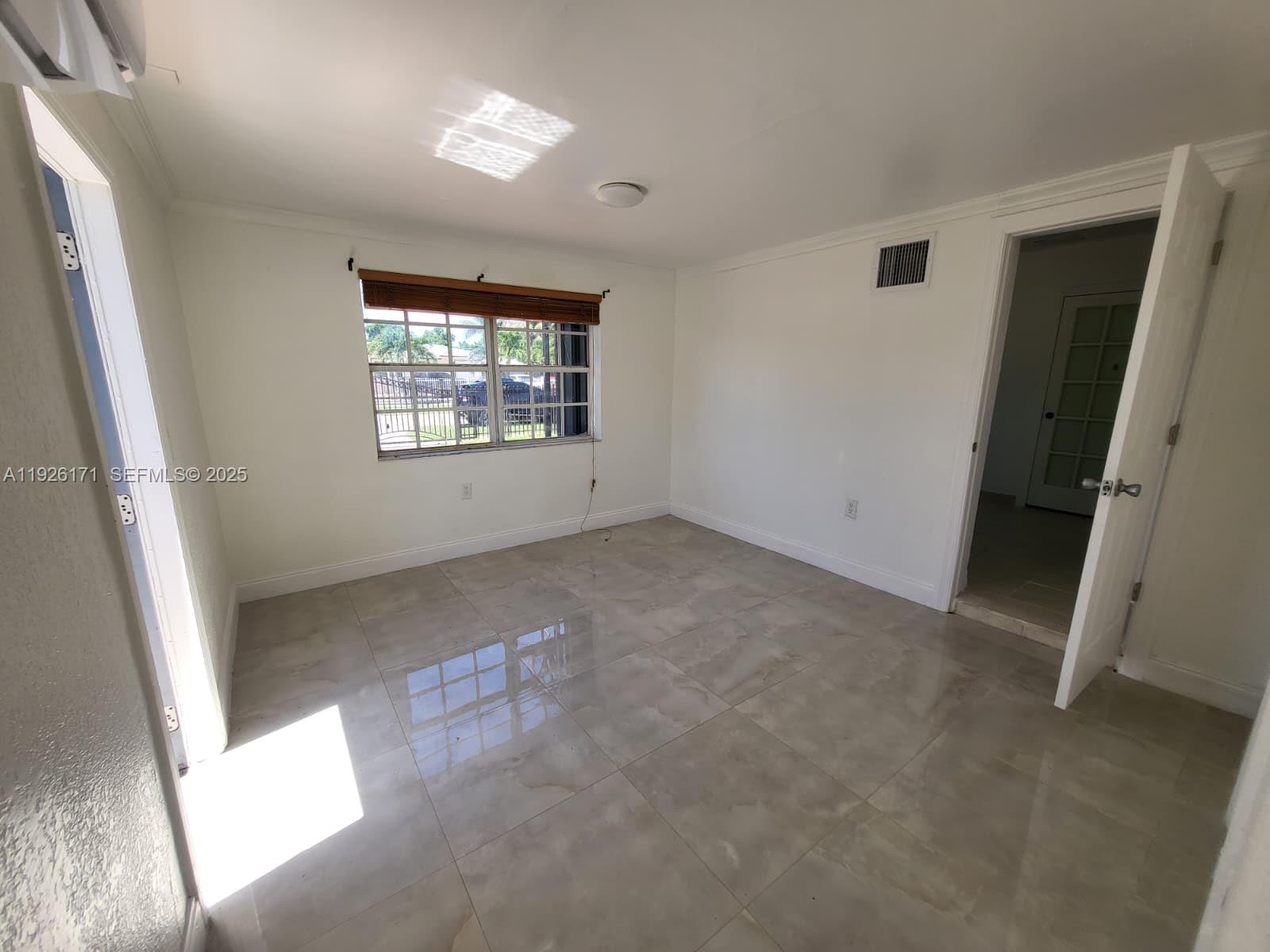 15320 Southwest 298th Terrace, Unit 15320 Homestead, FL 33033 - Photo 3 of 27 an empty room with windows