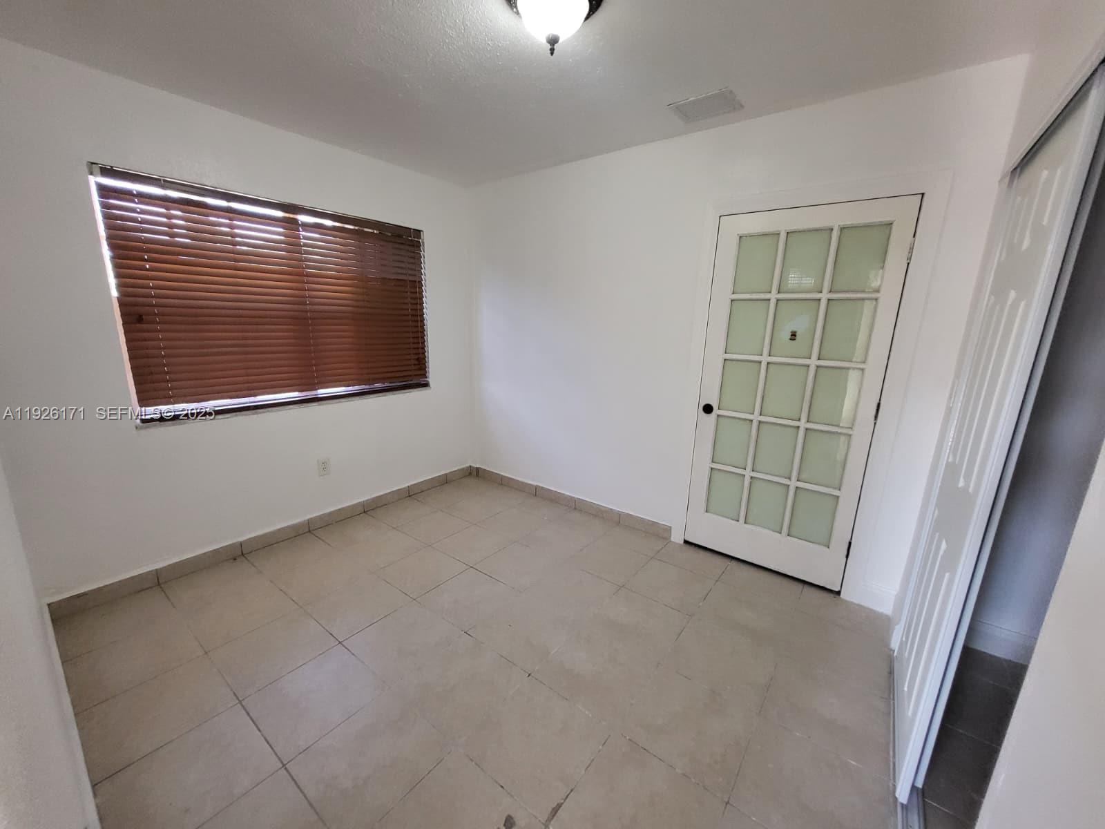 15320 Southwest 298th Terrace, Unit 15320 Homestead, FL 33033 - Photo 8 of 27 an empty room with windows