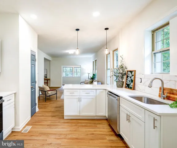 a large kitchen with kitchen island white cabinets and sink