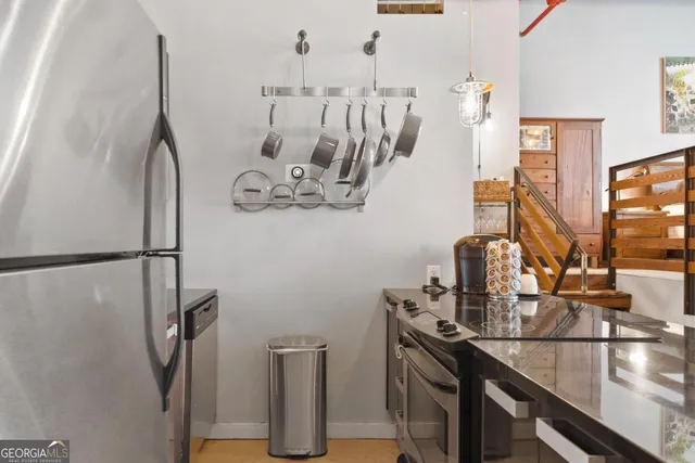 a living room with dining table and a refrigerator