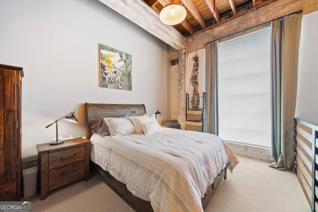 a bedroom with bed and paintings on the wall