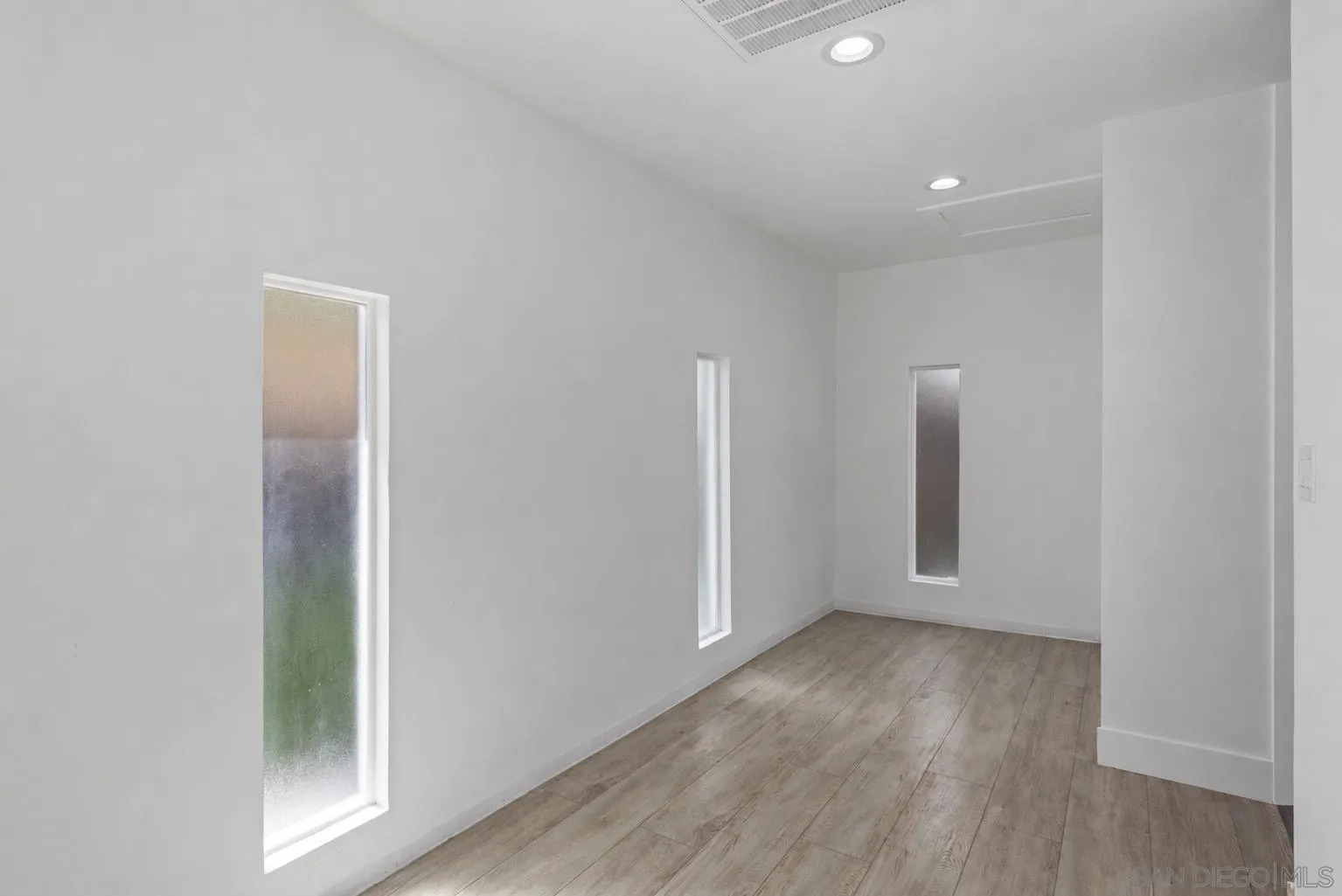 521 Rancho Camino Fallbrook, CA 92028 - Photo 34 of 72 an empty room with wooden floor and windows