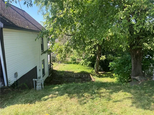 a view of house with backyard and deck