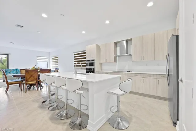 a kitchen with white cabinets and chairs