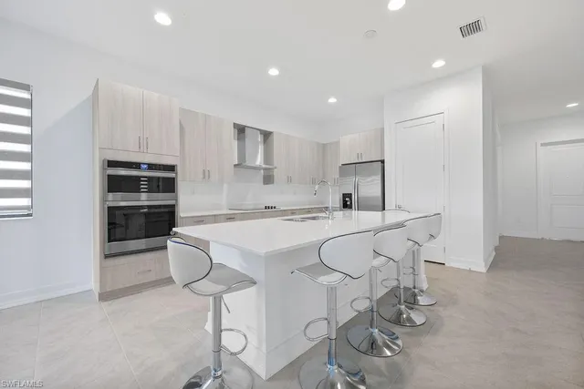 a kitchen with stainless steel appliances a sink stove and white cabinets