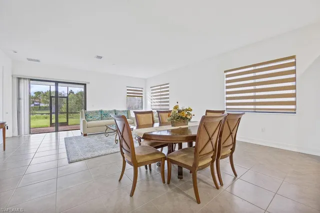 a dining room with furniture and large windows