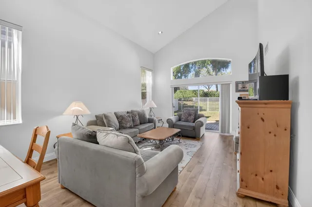 a living room with furniture a large window and a flat screen tv