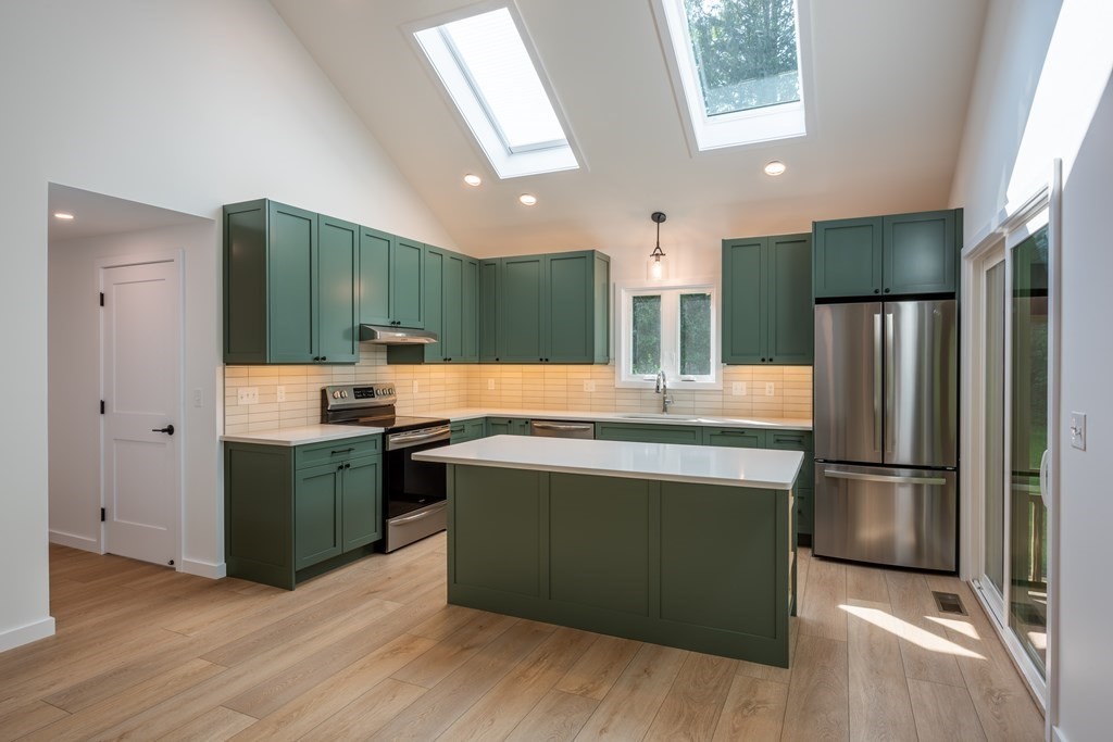 90 Memorial Drive Amherst, MA 01002 - Photo 4 of 38 a kitchen with kitchen island stainless steel appliances wooden floor and refrigerator