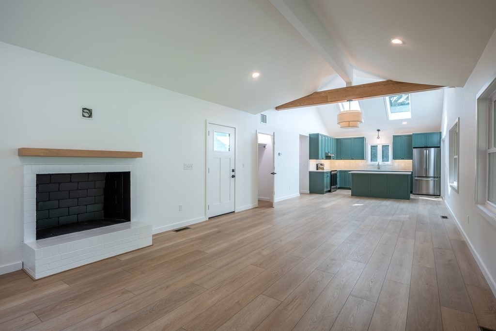 90 Memorial Drive Amherst, MA 01002 - Photo 5 of 38 an empty room with kitchen and fireplace