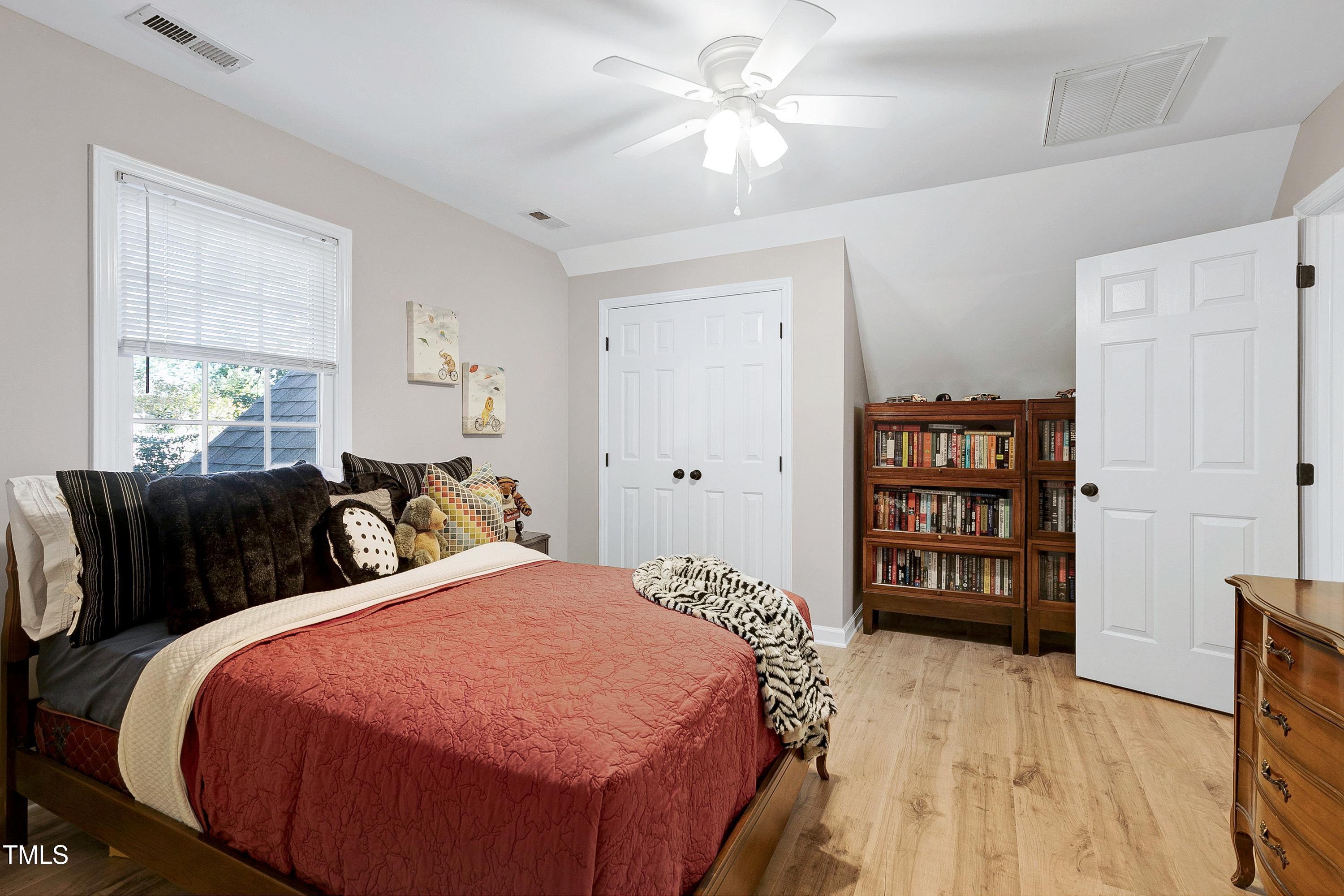 7834 James Austin Road Willow Spring, NC 27592 - Photo 25 of 46 a bed room with a bed and a book shelf