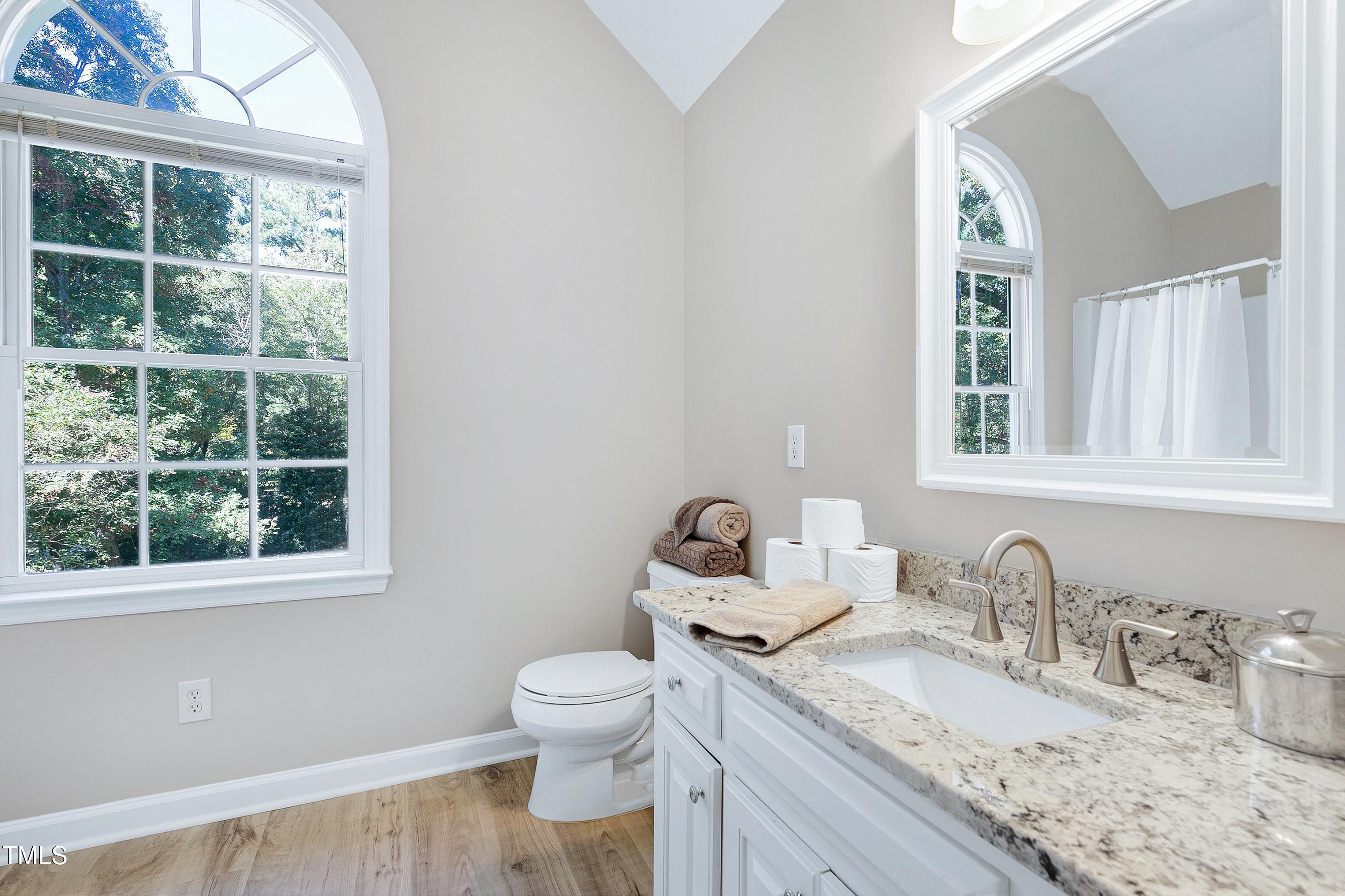 7834 James Austin Road Willow Spring, NC 27592 - Photo 31 of 46 a bathroom with a granite countertop sink toilet and a window