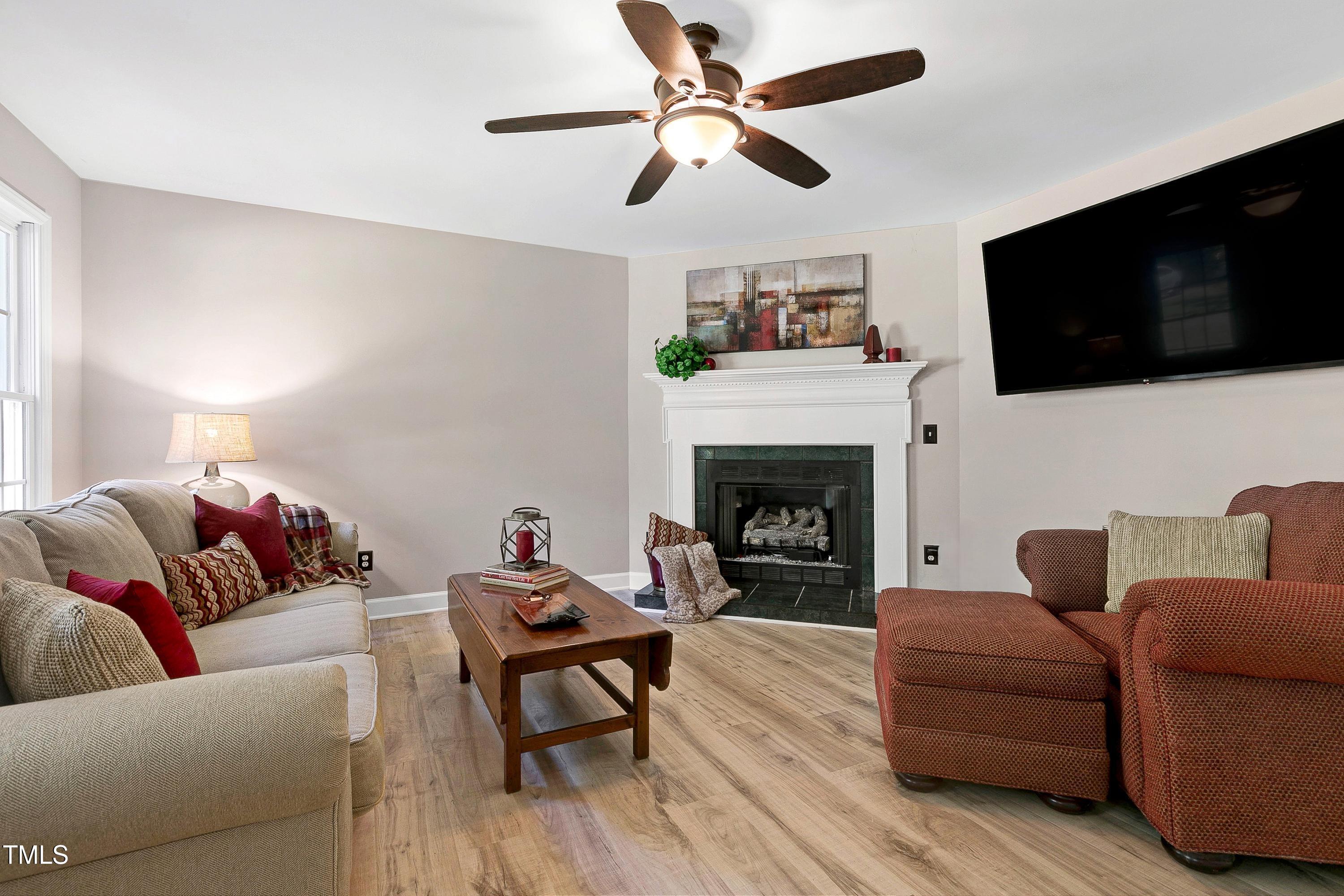 7834 James Austin Road Willow Spring, NC 27592 - Photo 8 of 46 a living room with furniture a flat screen tv and a fireplace