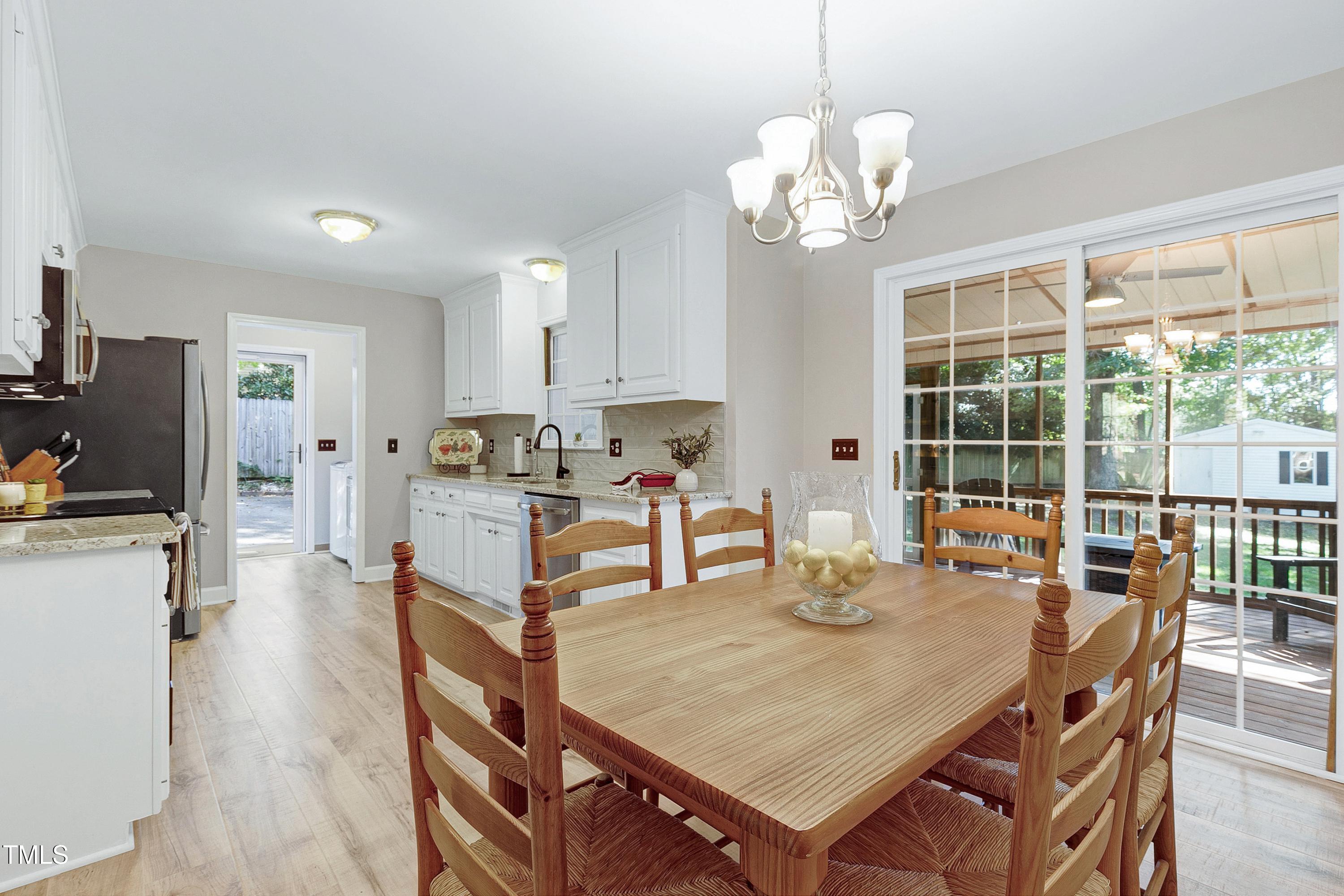 7834 James Austin Road Willow Spring, NC 27592 - Photo 10 of 46 a dining room with furniture a chandelier and window