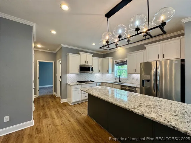 a kitchen with stainless steel appliances granite countertop a sink a stove and a refrigerator