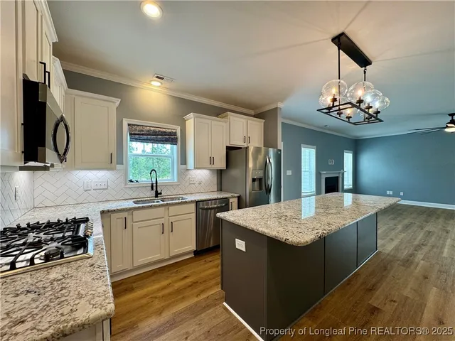 a large kitchen with kitchen island a sink stainless steel appliances and cabinets