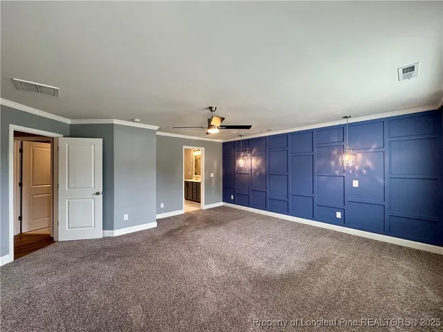 a view of a big room with windows and chandelier fan