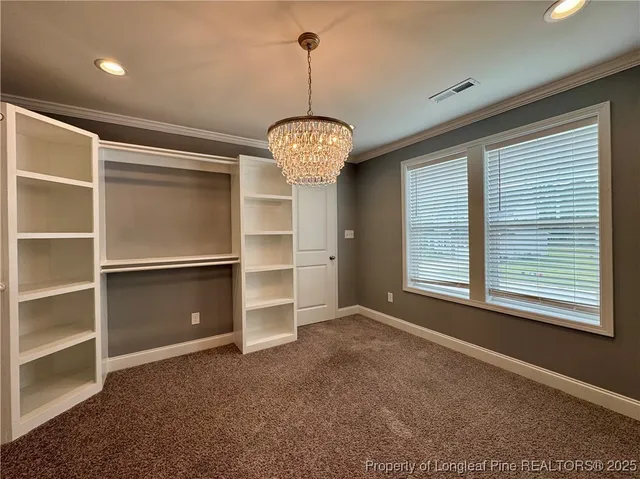 a view of an empty room with a window and a kitchen