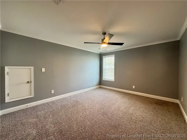 a view of an empty room with a chandelier fan