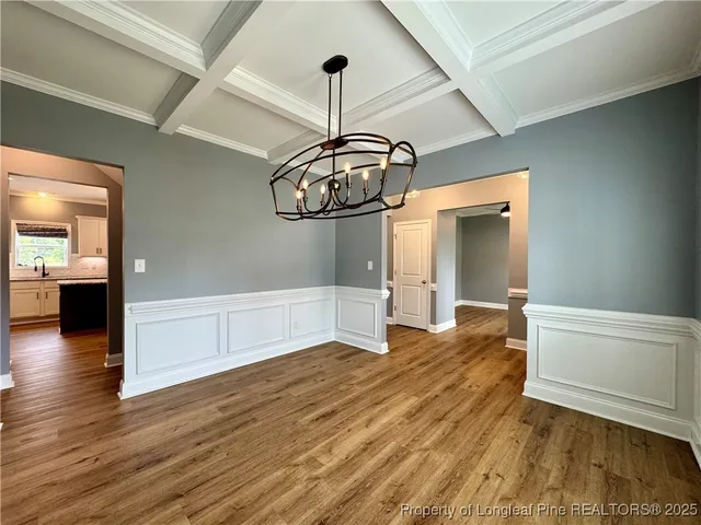 a view of a room with wooden floor staircase and a kitchen space