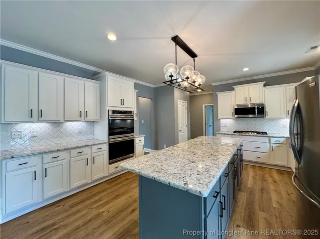 a kitchen with stainless steel appliances granite countertop a sink refrigerator and microwave
