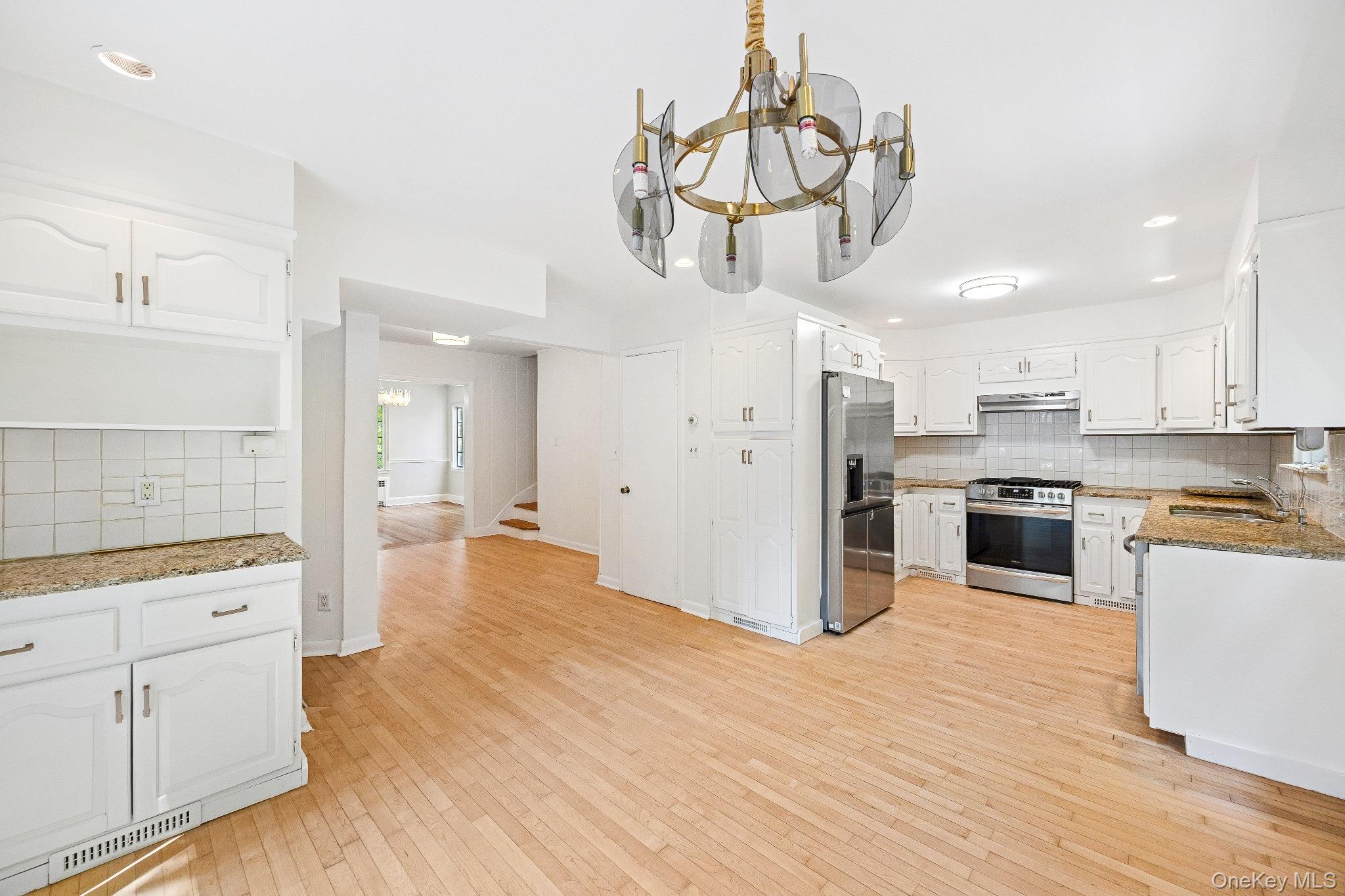 10 River Road Scarsdale, NY 10583 - Photo 10 of 20 Kitchen featuring decorative backsplash, a chandelier, recessed lighting, light wood-style floors, and appliances with stainless steel finishes