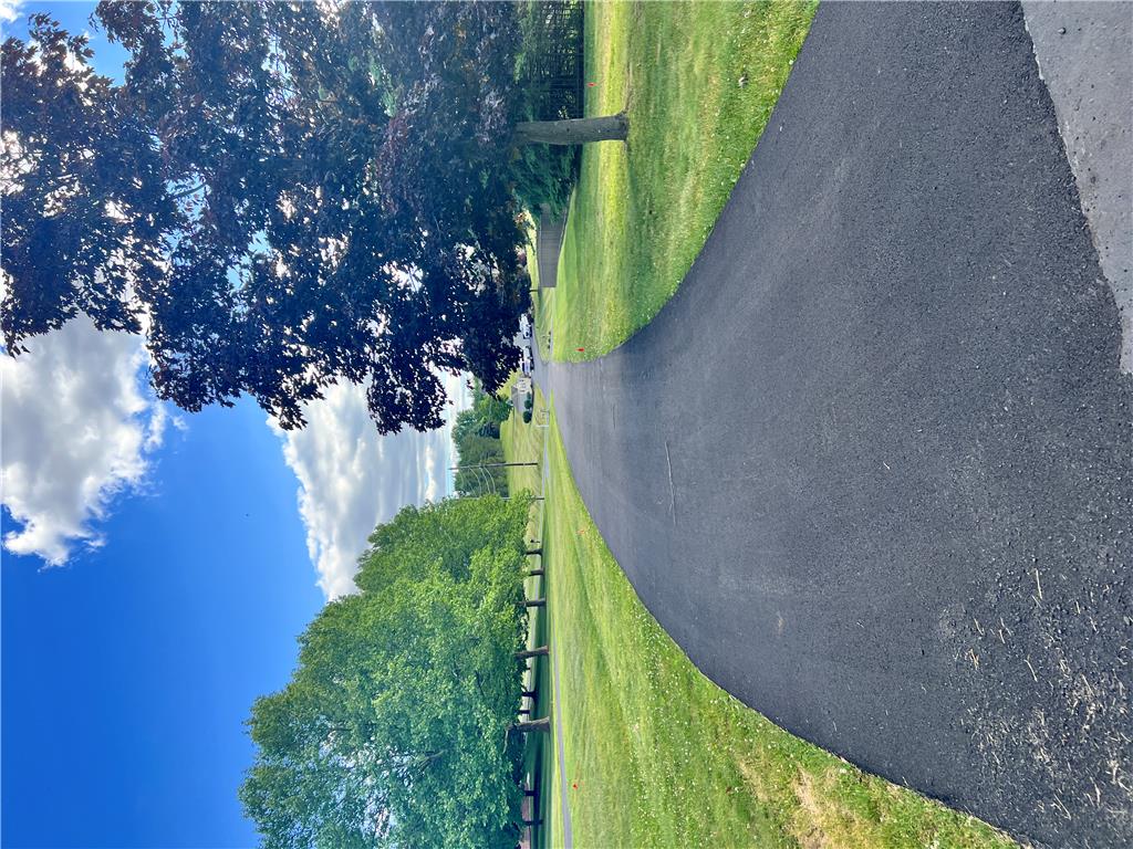 630 Clearfield Road Nazareth, PA 18064 - Photo 2 of 8 An inviting asphalt driveway winds through verdant lawns, shaded by mature trees.