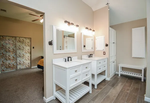 a spacious bathroom with a double vanity sink a mirror and a bathtub