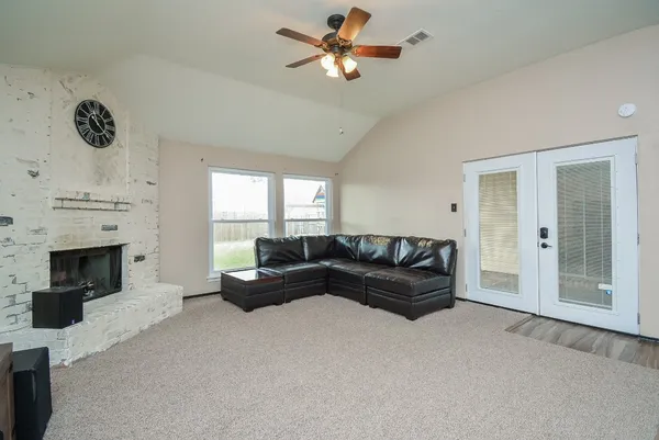 a living room with furniture a fireplace and a ceiling fan