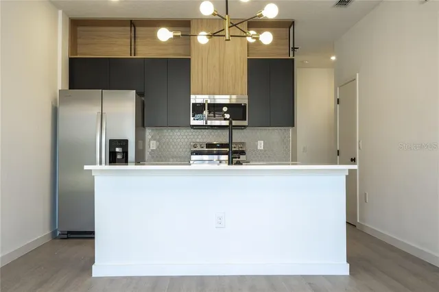 a kitchen with a refrigerator a sink and a microwave