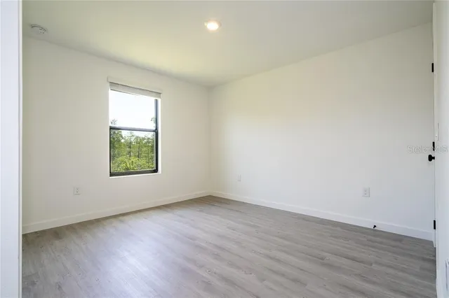 an empty room with a hardwood and a window