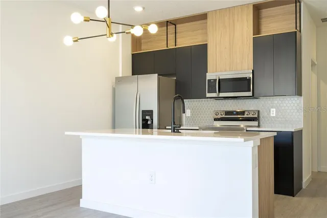 a kitchen with stainless steel appliances a refrigerator and a stove top oven