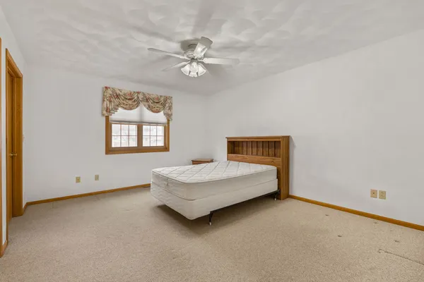 a spacious bedroom with a bed and a window