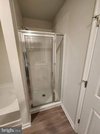 a white bath tub and shower in a window