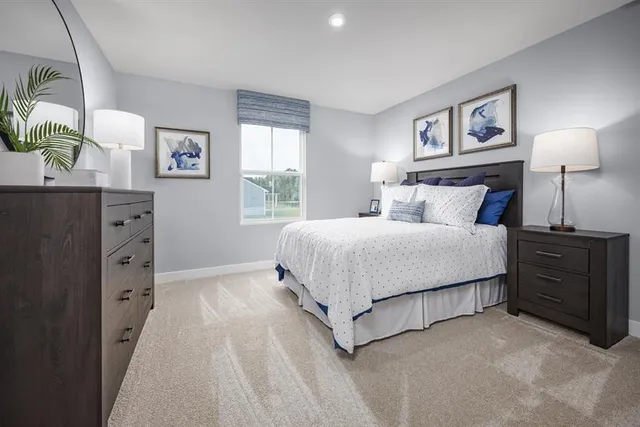 a bedroom with a bed and a lamp on dresser