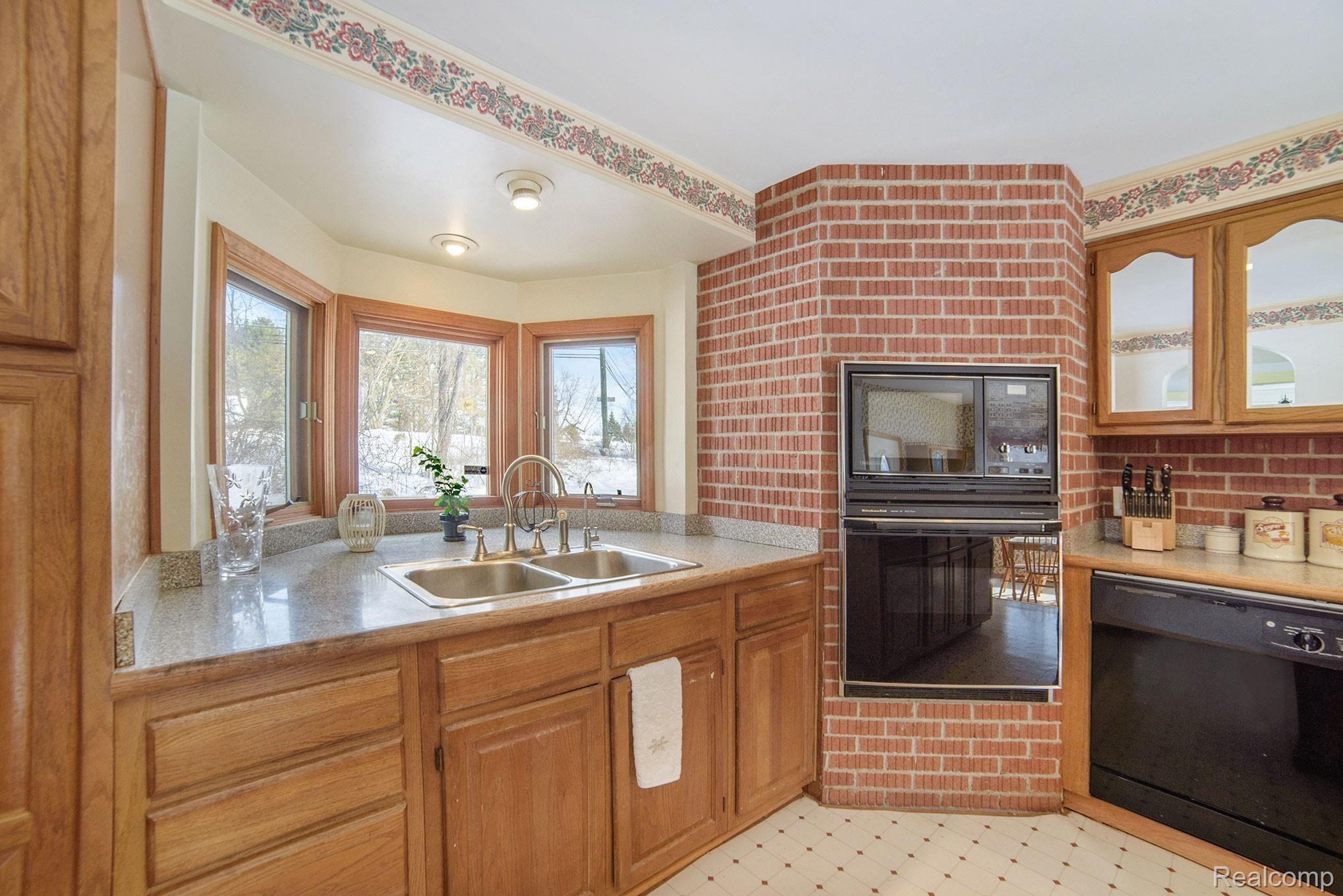 1458 Rochester Road Leonard, MI 48367 - Photo 7 of 32 Large bay window behind sink, flooding kitchen with natural light, feature built in oven/microwave