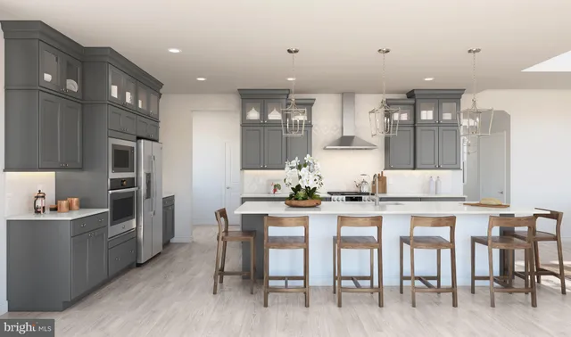 a kitchen with stainless steel appliances kitchen island granite countertop a table chairs sink and cabinets