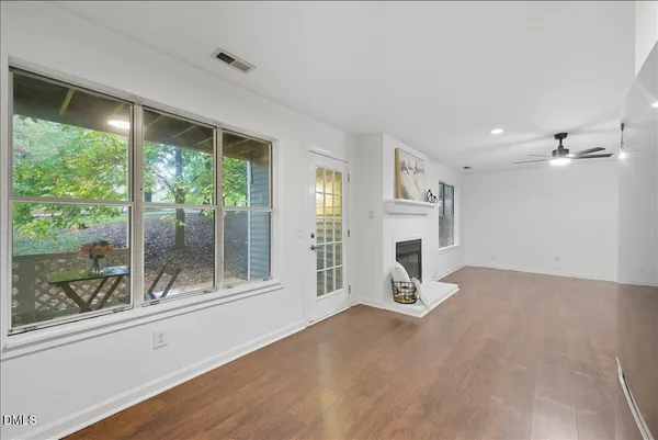 a view of an empty room with a fireplace and windows