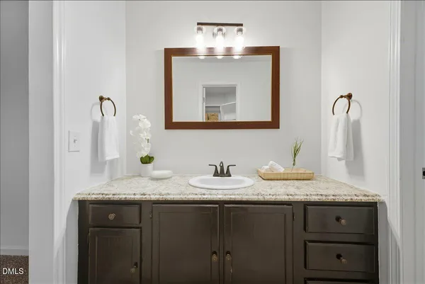 a bathroom with a granite countertop sink and a mirror