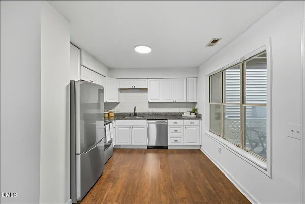a kitchen with a refrigerator a sink and cabinets