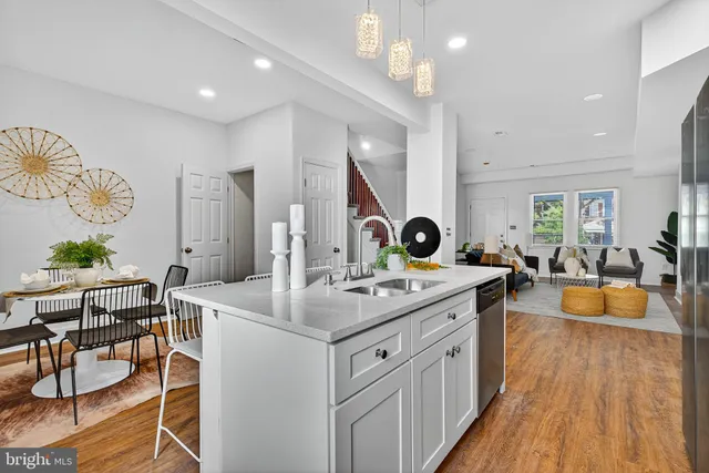 a kitchen with a sink stove and wooden floor