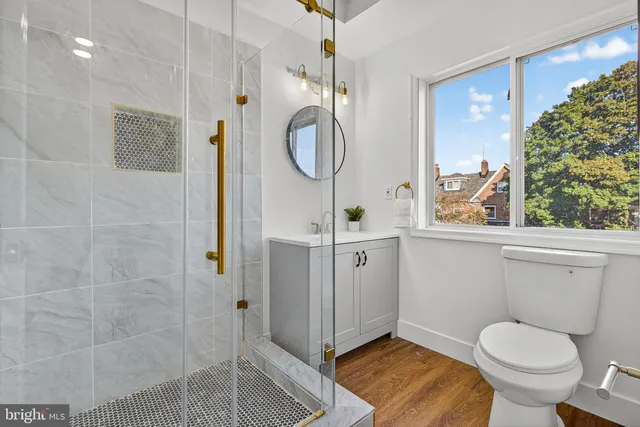 a bathroom with a toilet a sink and mirror