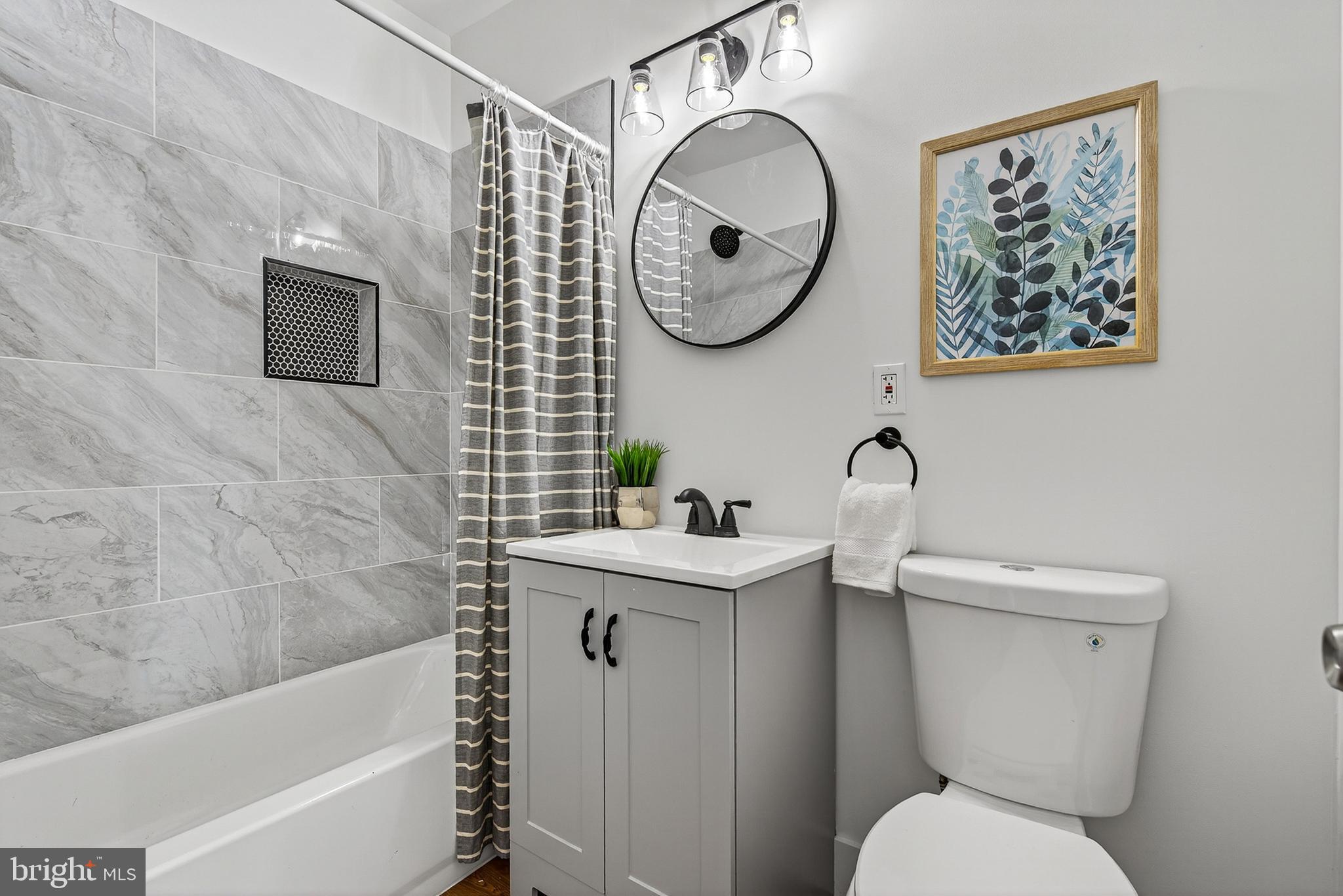 802 North Woodington Road Baltimore, MD 21229 - Photo 21 of 41 a bathroom with a toilet a sink and mirror