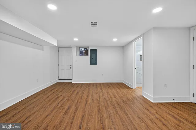a view of an empty room with wooden floor