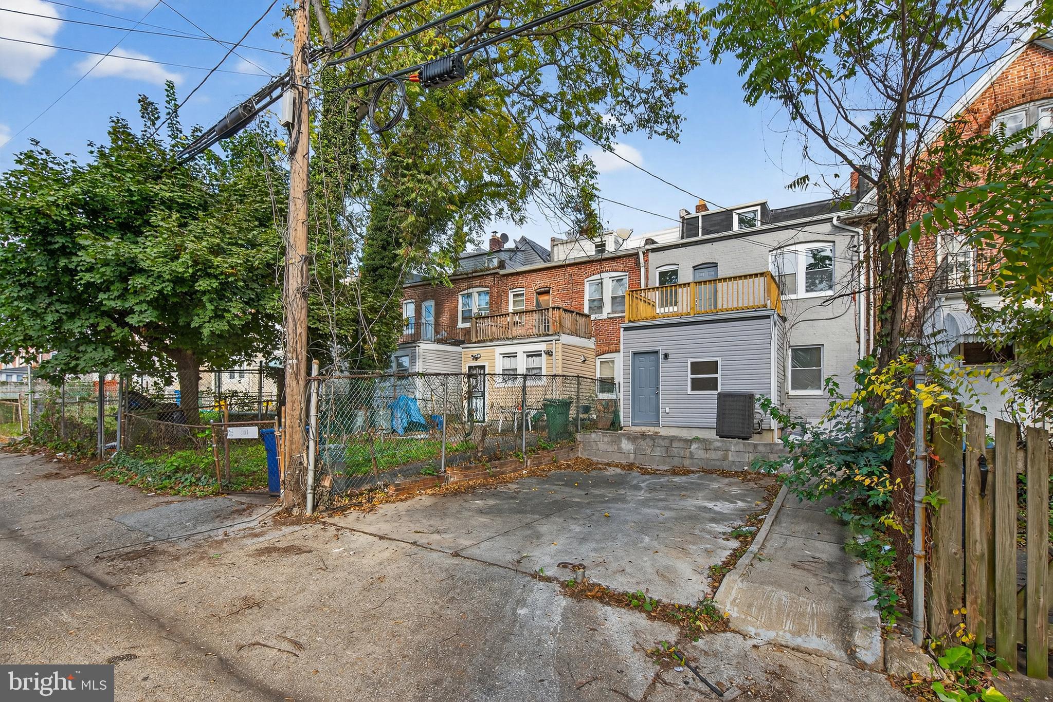 802 North Woodington Road Baltimore, MD 21229 - Photo 38 of 41 a view of a white house next to a yard with large trees